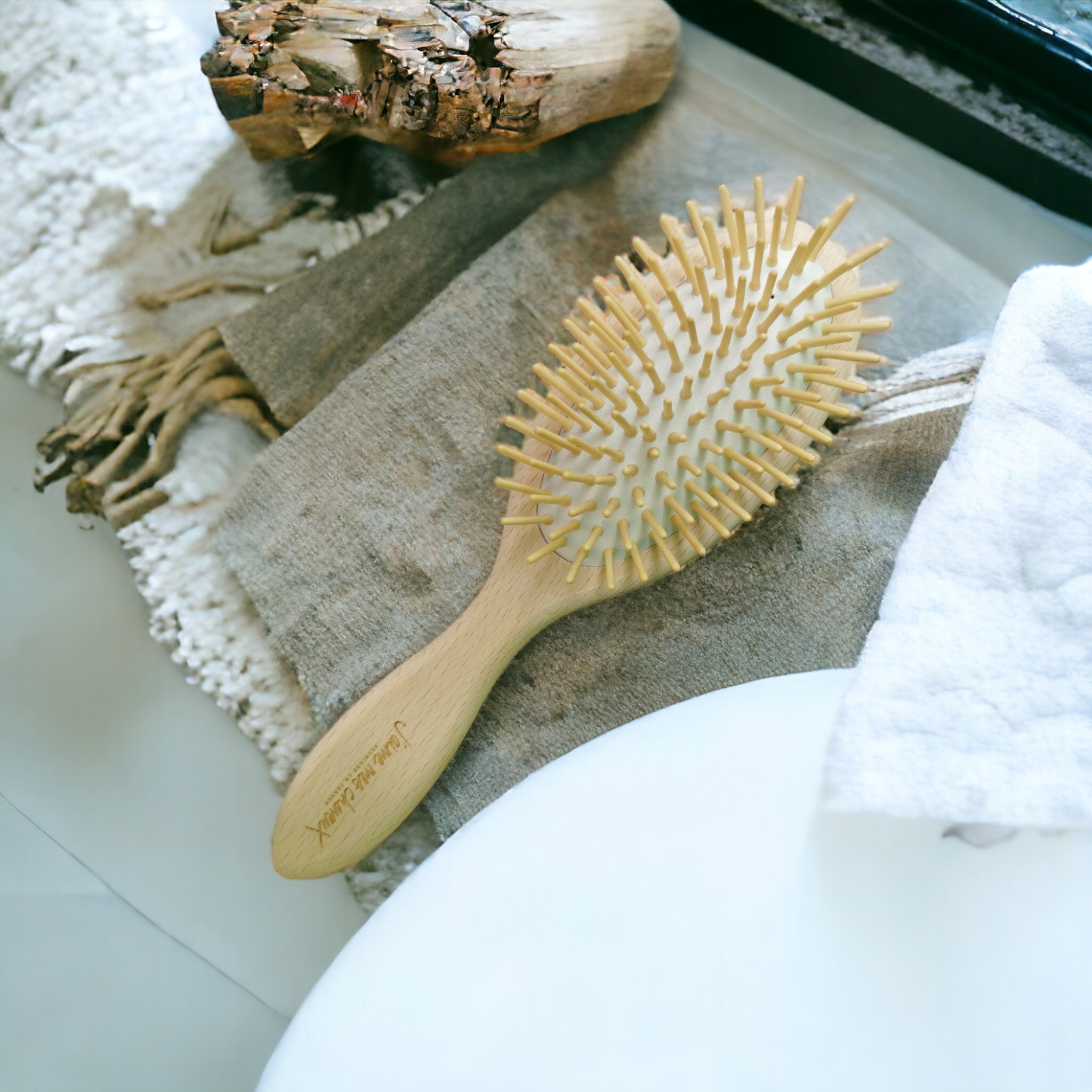 natürliche haarbürste aus holz mit holzborsten platziert im Badezimmer auf einem handtuch