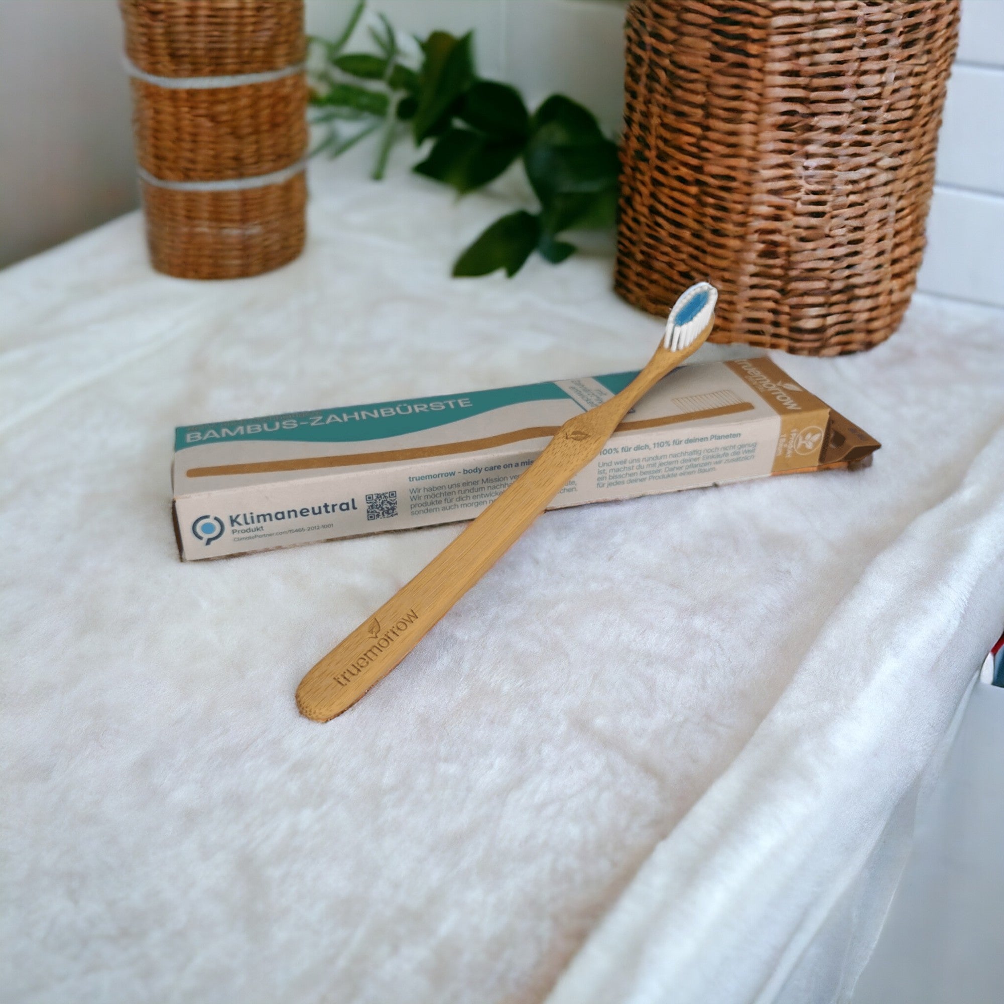 truemorrow Zahnbürste aus Bambus platziert im Badezimmer mit Bambus im Hintergrund